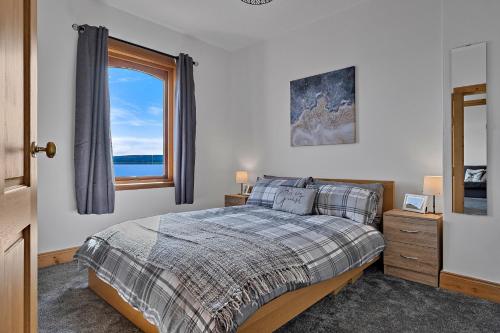 a bedroom with a bed and a large window at Finest Retreats - The Sea Cottage in Avoch