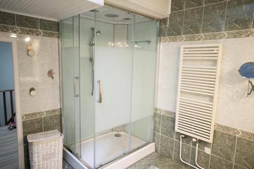 La salle de bains est pourvue d'une douche avec une porte en verre. dans l'établissement Les 2 glycines Au coeur des vignobles et de parcours de golfs, à Libourne