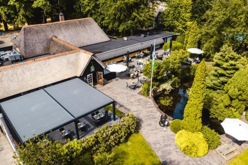 an overhead view of a building with a patio and a pond at De Lunterse Boer in Lunteren