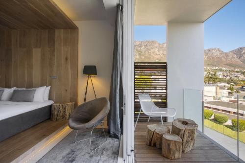 a bedroom with a bed and a view of the mountains at POD Camps Bay by The Oyster Collection in Cape Town