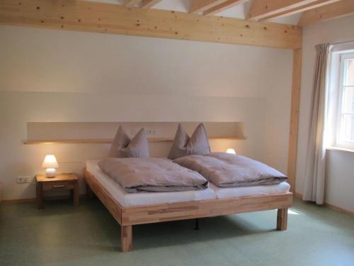 a bed in a room with two pillows on it at Exklusives Holzhaus in Kolonie