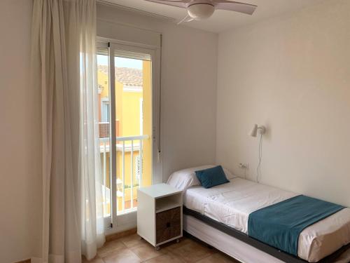 a small bedroom with a bed and a window at Kione Bellamar in Alcossebre