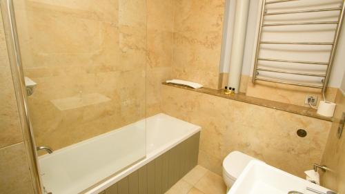 La salle de bains est pourvue d'une baignoire, de toilettes et d'un lavabo. dans l'établissement The Rest Hotel, à Lincoln