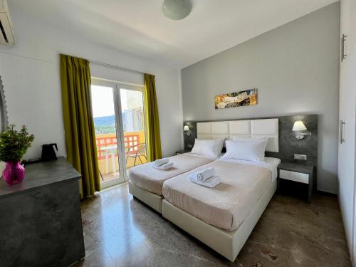ein Schlafzimmer mit einem großen Bett und einem großen Fenster in der Unterkunft Maria Hotel Sisi in Sisi