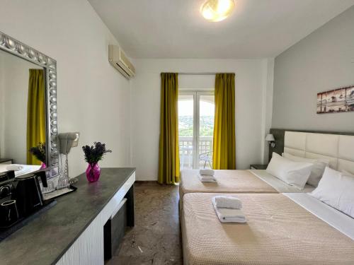 a hotel room with two beds and a mirror at Maria Hotel Sisi in Sissi