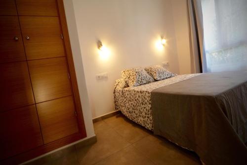 een slaapkamer met een bed, een dressoir en een raam bij Hacienda Laguna Seca - Apart. Hibisco in Chiclana de la Frontera