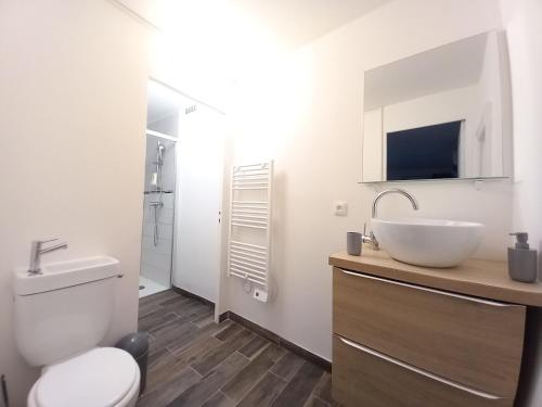 a white bathroom with a sink and a toilet at Maison et Appartements d'Anatole France proche Centre-Ville, Université - CHU, Patinoire et Futuroscope in Poitiers