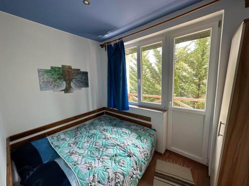 a small bedroom with a bed and a window at THERMÁL vendégház in Sárospatak
