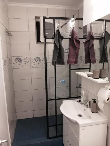 a bathroom with a sink and a shower with towels at Concordia Apartament in Brăila