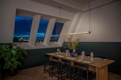 a room with a table with chairs and windows at Almanac X Alcron Prague in Prague