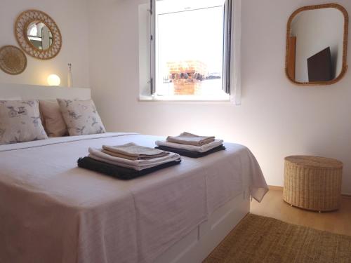 a white bedroom with a bed with towels on it at Eco Apartments Kate in Suđurađ