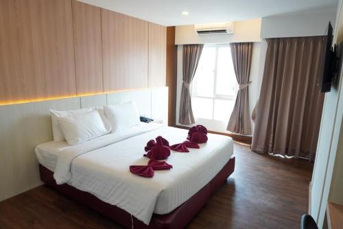 a hotel room with a bed with red bows on it at M CASA HOTEL PATTAYA in Nong Prue
