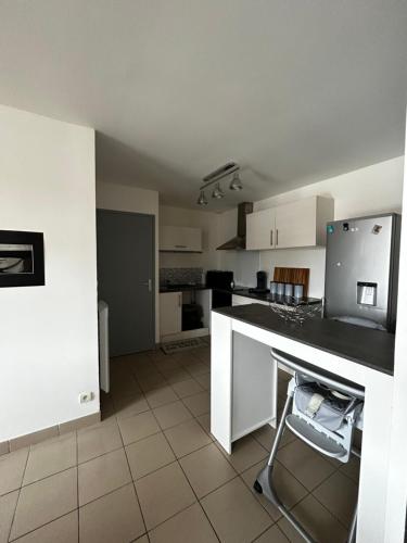 a kitchen with white cabinets and a black counter top at Grand T4 à 150m de la Plage in Le Portel