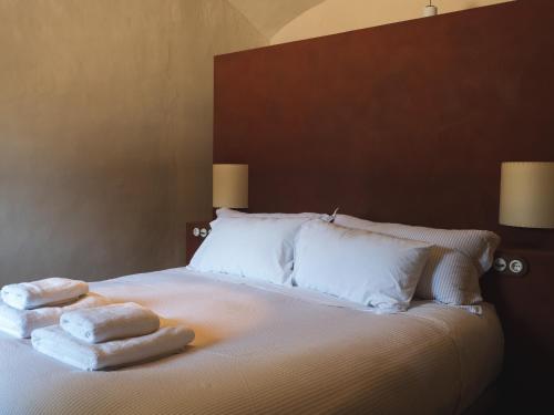 a bed with two towels sitting on top of it at Can Campolier in Porqueres
