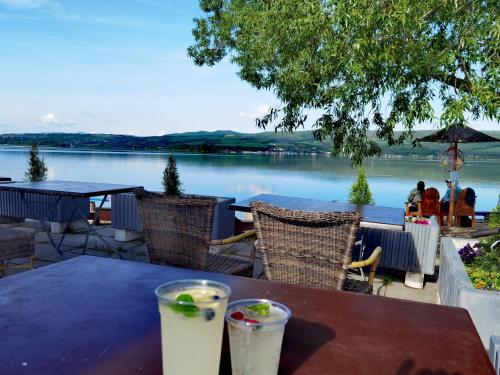 a table with drinks on it with a view of a lake at Sunset House Piešťany Červená Veža in Banka