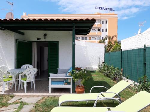 d'une terrasse avec une table, des chaises et une clôture. dans l'établissement bungalow with private garden, à Playa del Ingles