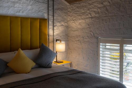 a bedroom with a bed with a yellow headboard and a window at Number 31 in Dublin