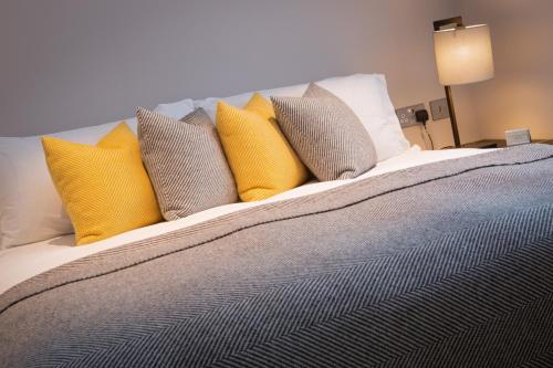 a bed with yellow and gray pillows on it at Number 31 in Dublin