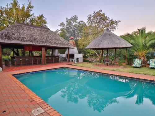 a swimming pool with a gazebo and a resort at Thuto Centre Conferencing & Bush Lodge in Bela-Bela