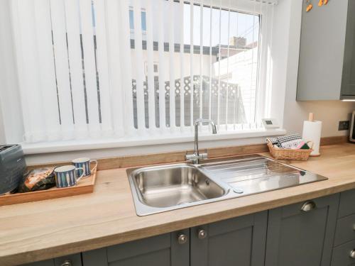 a kitchen counter with a sink and a window at Stone's Throw in Morpeth