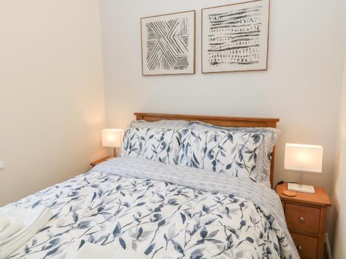 a bedroom with a bed and two pictures on the wall at Stone's Throw in Morpeth