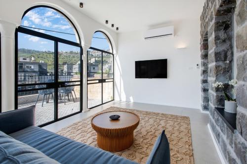 a living room with a blue couch and a table at UG Boutique - סוויטות מדהימות ומעוצבות מול הכנרת in Tiberias