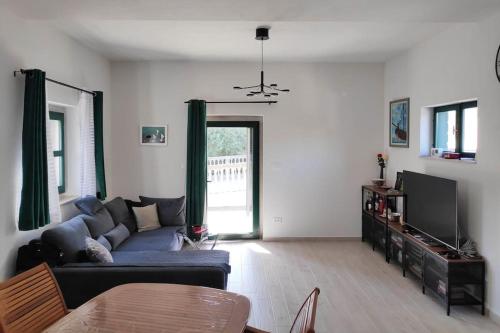 un soggiorno con divano blu e TV di Mala Villa a Kaštela (Castelli)