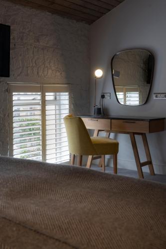 a bedroom with a desk with a mirror and a chair at Number 31 in Dublin