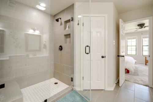 een witte badkamer met een douche en een glazen deur bij Spacious Austin Vacation Rental with Deck! in Dripping Springs