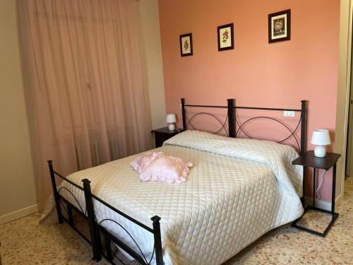 a bedroom with a bed with a pink pillow on it at VILLA DEL COLLE CAMERA MERLOT in Torre del Colle