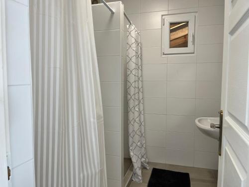 a bathroom with a shower curtain and a sink at Fészek Vendégház in Zalaegerszeg