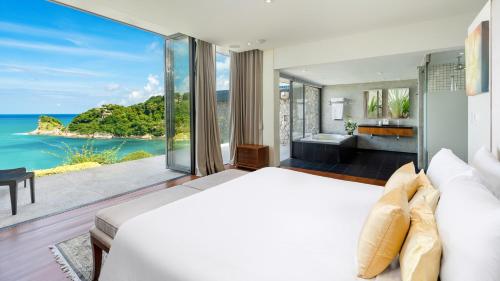 a bedroom with a bed and a view of the ocean at Villa Viman in Kathu
