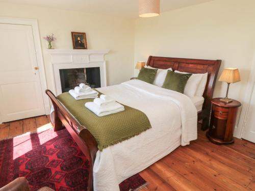 a bedroom with a large bed with towels on it at Harnham Hall Cottage in Newcastle upon Tyne