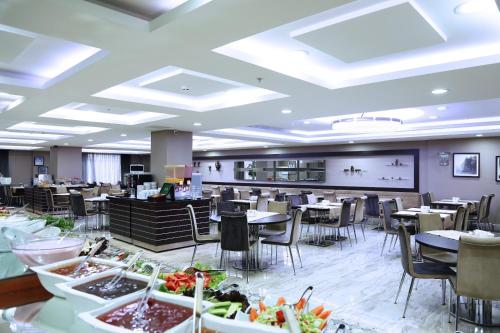 a dining room with tables and chairs and a cafeteria at Benler Otel Laleli ISTanbul in Istanbul