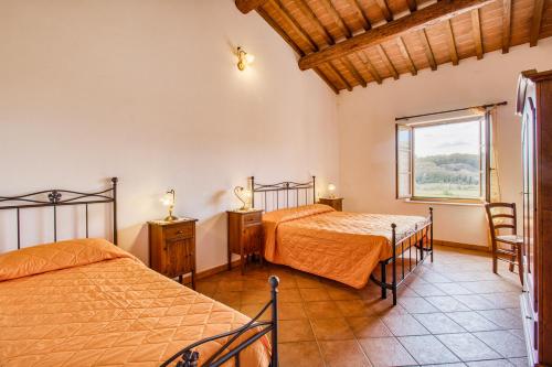 1 Schlafzimmer mit 2 Betten und einem Fenster in der Unterkunft Villa Santarcangelo With Pool - Happy Rentals in Asciano
