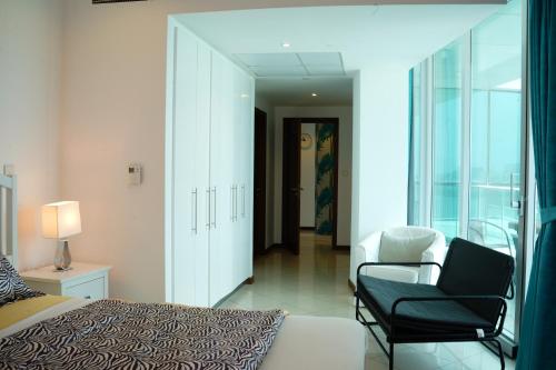 a bedroom with a bed and a chair and a window at Luxurious Penthouses in Dubai