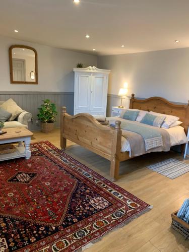 a bedroom with a wooden bed and a rug at Little Banks Cabin in Ringwood