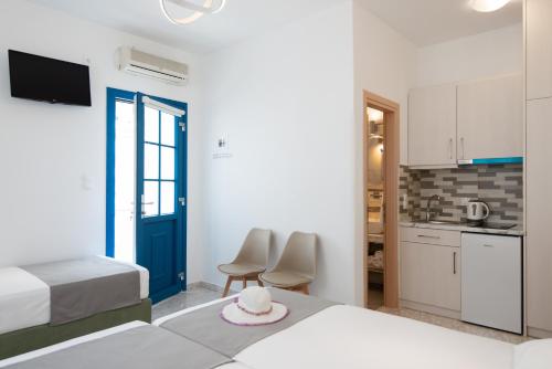 Habitación de hotel con 2 camas y cocina en Theodora Rooms, en Kamarai
