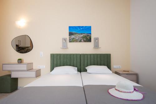 a bedroom with a bed with a hat on it at Theodora Rooms in Kamarai