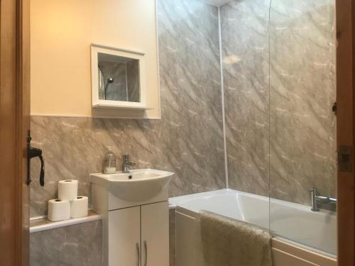 y baño con lavabo, ducha y bañera. en Recently renovated 3-Bed Apartment on Exmoor, en Minehead