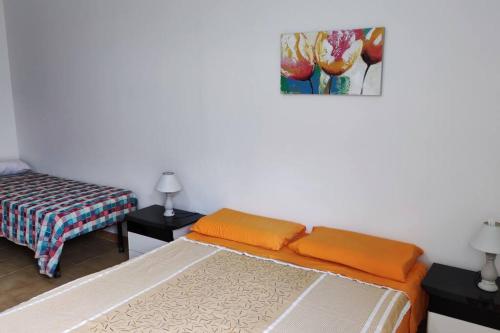 um quarto com duas camas e um quadro na parede em Appartamento vista mare em Nicotera Marina