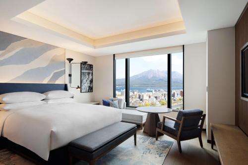 a bedroom with a bed and a view of a city at Sheraton Kagoshima in Kagoshima