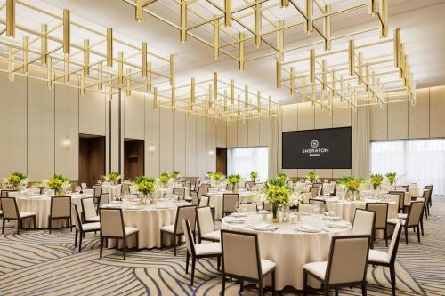 a conference room with tables and chairs and chandeliers at Sheraton Kagoshima in Kagoshima