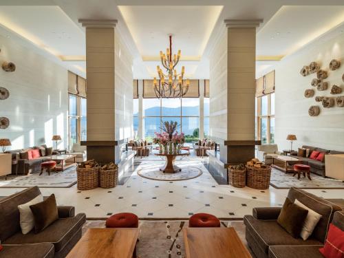 a lobby with couches and tables and a chandelier at The Europe Hotel & Resort in Killarney