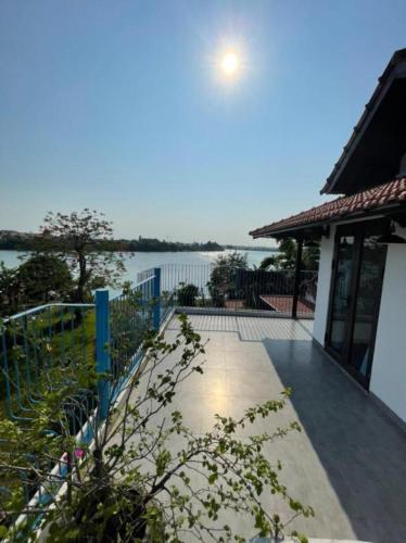 a house with a fence and a view of the water at La Y Riverview in Hue
