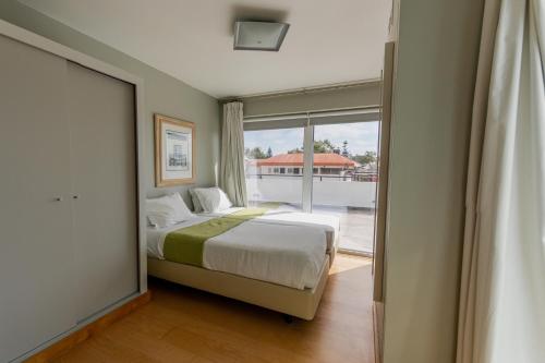 a bedroom with a bed and a large window at Cascais Hotel in Cascais