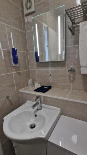 a bathroom with a sink and a mirror at Corona Blackpool in Blackpool