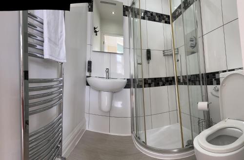 y baño con aseo, lavabo y ducha. en Alum Chine Beach House, en Bournemouth