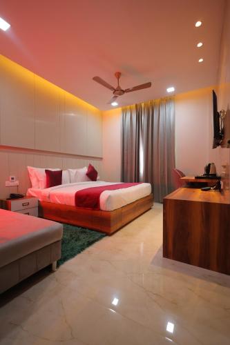 a bedroom with a bed and a couch and a television at Hotel Taj Crown Plaza - By BS Group Of Hotels in Agra