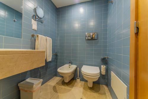 a blue bathroom with a toilet and a sink at Cascais Hotel in Cascais